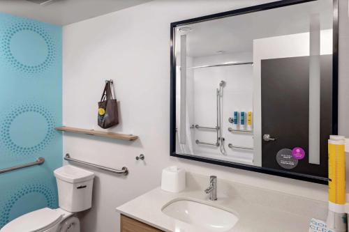 a bathroom with a toilet and a sink and a mirror at Tru By Hilton Crossett in Crossett