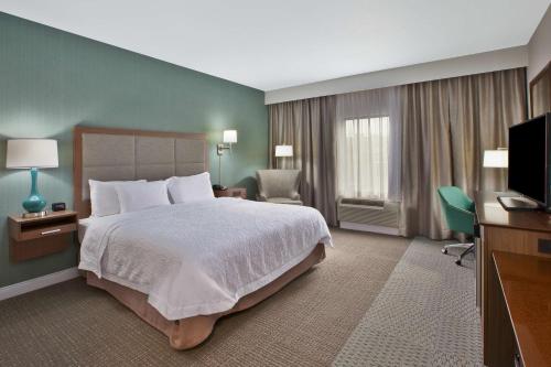Habitación de hotel con cama y TV en Hampton Inn & Suites Alliance, en Alliance