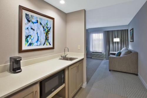 a kitchen with a sink and a living room at Hampton Inn & Suites Alliance in Alliance