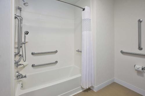 y baño blanco con ducha y bañera. en Hampton Inn & Suites Alliance, en Alliance