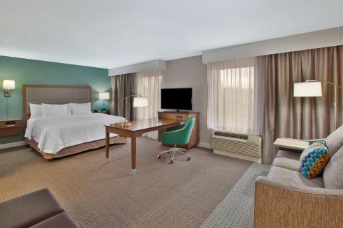 a large hotel room with a bed and a desk at Hampton Inn & Suites Alliance in Alliance