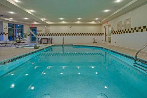 a large swimming pool with blue water in a building at Hilton Garden Inn Cleveland Airport in Fairview Park
