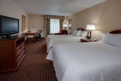 a hotel room with two beds and a flat screen tv at Hilton Garden Inn Cleveland Airport in Fairview Park