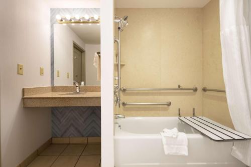 a bathroom with a tub and a sink at Hilton Garden Inn Mystic/Groton in Groton