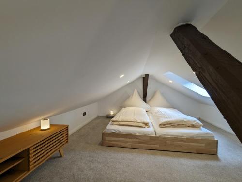Ferienhaus Tinyhouse21 Wasserkuppe في Obernhausen: غرفة نوم مع سرير وخزانة في العلية