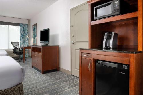 a hotel room with a bed and a microwave at Hilton Garden Inn Mystic/Groton in Groton