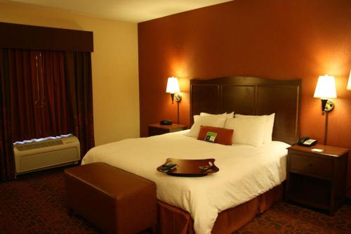 a hotel room with a large bed and a table at Hampton Inn & Suites New Castle, PA in New Castle
