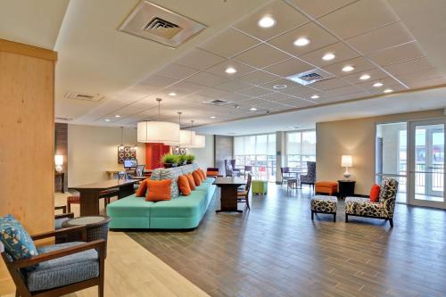 a lobby with a couch and a table and chairs at Home2 Suites By Hilton Meridian in Meridian