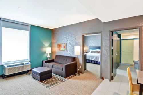 Habitación de hotel con sofá y cama en Home2 Suites By Hilton Meridian en Meridian