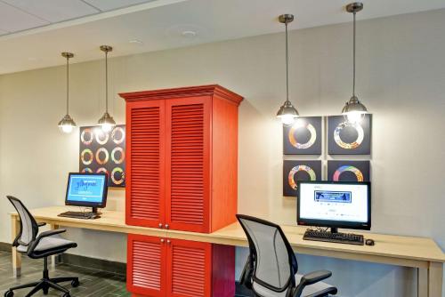 an office with red cabinets and a desk with two computers at Home2 Suites By Hilton Meridian in Meridian