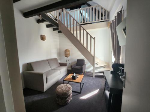 a living room with a couch and a staircase at Villa Pona in Digoin