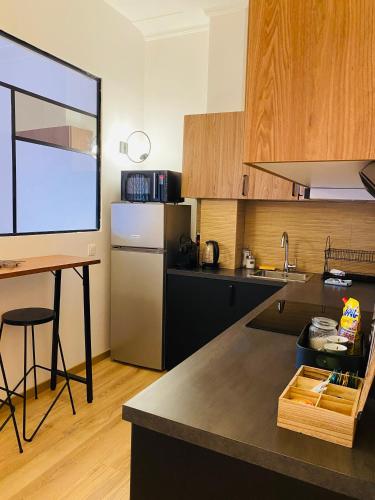 une cuisine avec une table et un comptoir dans l'établissement Le Jean Macé, 200m gare, clim., à Grenoble