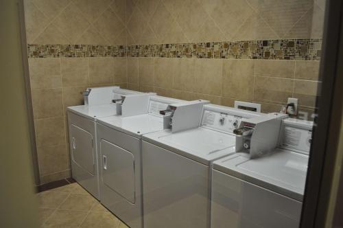 a row of white washing machines in a bathroom at Hampton Inn Pleasanton in Pleasanton