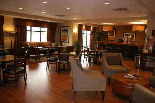 a restaurant with chairs and tables and a bar at Hampton Inn La Junta in La Junta