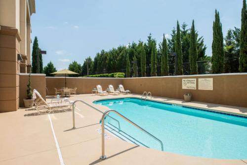 a swimming pool with chairs and a table at Hampton Inn Easley in Easley