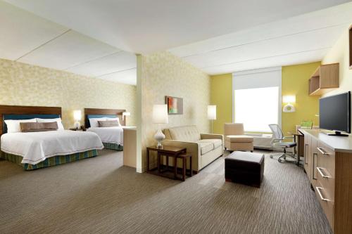 een hotelkamer met een bed en een woonkamer bij Home2 Suites by Hilton Saratoga Malta in Malta