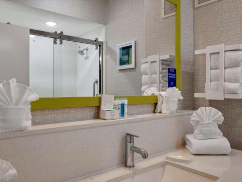 a bathroom with a sink and a mirror and towels at Hampton Inn and Suites Lufkin in Lufkin