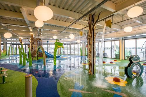 an indoor playground with a slide and swings at Lakes Breaks - 6 Meadows in Tattershall