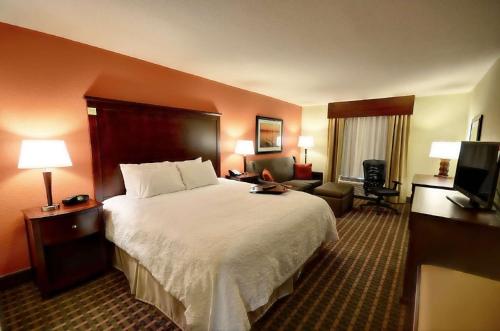 a hotel room with a large bed and a television at Hampton Inn & Suites Tifton in Tifton