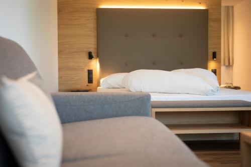 a bedroom with a bed and a chair at Natur Residence Kaiser Hans in Schenna
