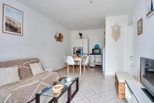 un salon avec un canapé et une table dans l'établissement 100m de la plage des Mouettes, appartement pour 4, à Saint-Hilaire-de-Riez