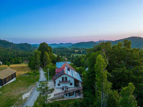 an aerial view of a house with a blue roof at Mountain Escape house with indoor pool in Fužine