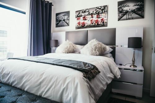 a bedroom with a white bed with two pillows at Sizakele Stays in Johannesburg