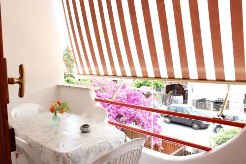einen Balkon mit einem Tisch und Blick auf ein Auto in der Unterkunft Roma a un passo e il mare in casa in Marina di Cerveteri
