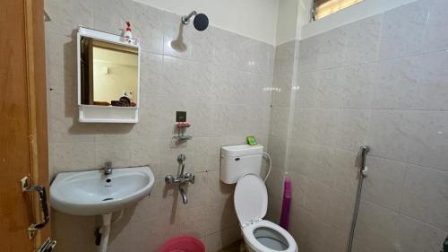 a bathroom with a toilet and a sink at Casa de Sanchi in Puttaparthi