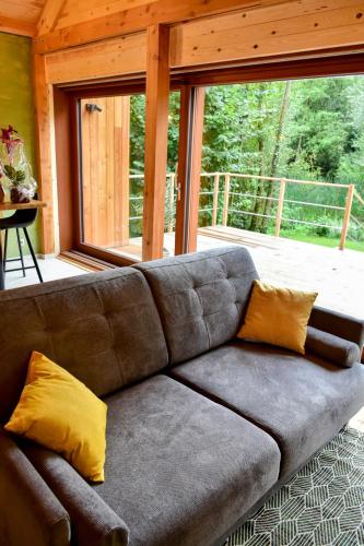 a couch in a living room with a large window at Entre mare et chêne in Frasnes-lez-Anvaing
