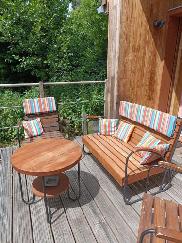 a wooden bench and two chairs on a deck at Entre mare et chêne in Frasnes-lez-Anvaing