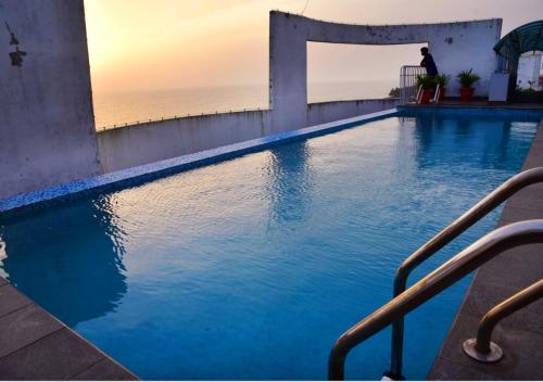 una piscina con el océano en el fondo en Seaview with Infinity Pool, en Kozhikode