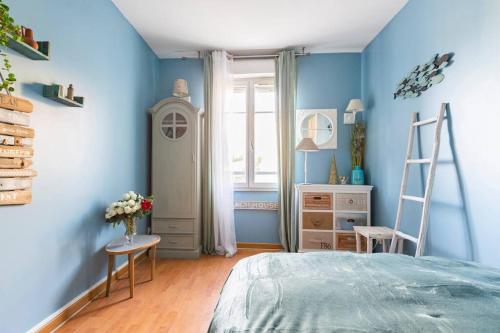 ein Schlafzimmer mit blauen Wänden und einem Bett und einer Leiter in der Unterkunft Appartement 4 pièces proche Paris et Disneyland in Fontenay-sous-Bois