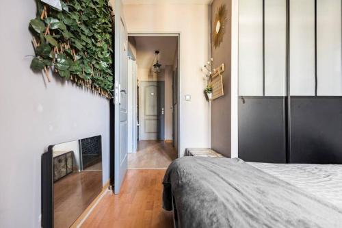 een slaapkamer met een plant aan de muur bij Appart 4 pièces proche Site jeux Olympiques Disneyland et Paris in Fontenay-sous-Bois