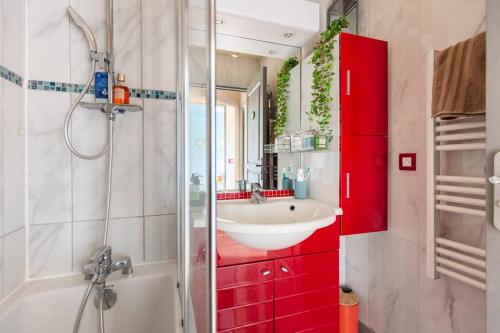 een badkamer met een wastafel en een rode kast bij Appart 4 pièces proche Site jeux Olympiques Disneyland et Paris in Fontenay-sous-Bois