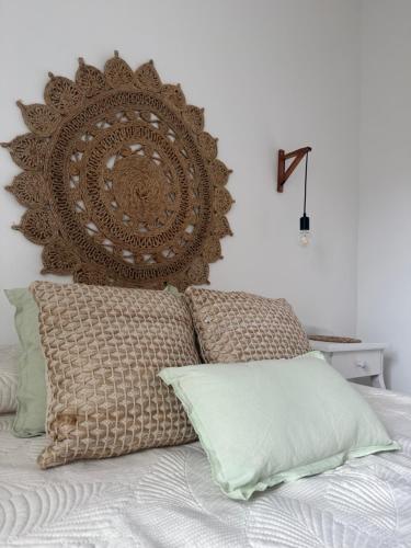 a bed with pillows and a decorative head board at Sa Caseta d'Artrutx in Cala en Bosc