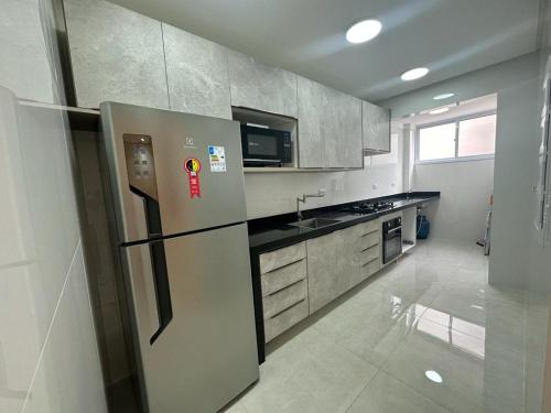 a kitchen with a stainless steel refrigerator in at Refúgio Costeiro in Guarujá