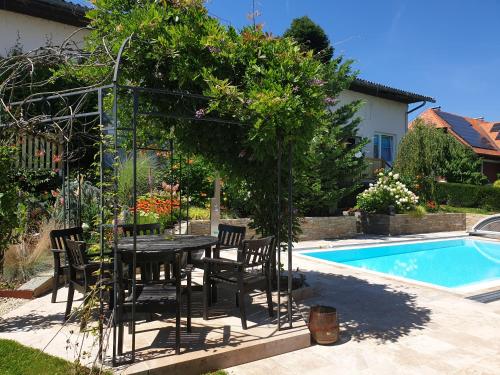 a patio with a table and chairs next to a pool at Ferienwohnung mit Pool an der Apfelstraße in Puch bei Weiz