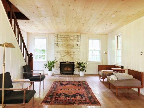 a living room with a fireplace and a table and chairs at Mountain Farmhouse (The Lorca, Catskills) in Shandaken