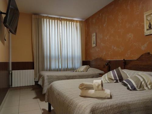 a hotel room with two beds with towels on them at Mitru Express Tupiza in Tupiza