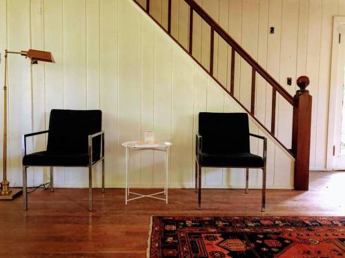 two chairs and a table in a room with a staircase at Mountain Farmhouse (The Lorca, Catskills) in Shandaken