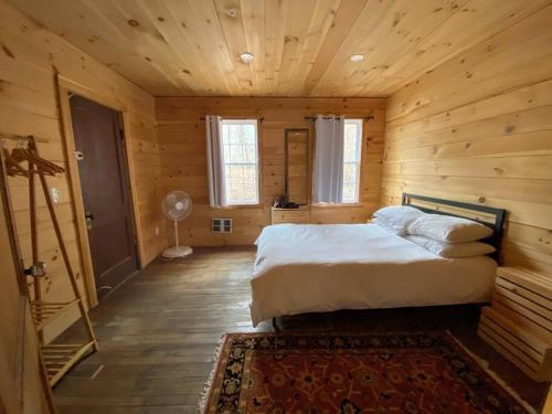 1 dormitorio con 1 cama en una cabaña de madera en Mountain Farmhouse (The Lorca, Catskills), en Shandaken