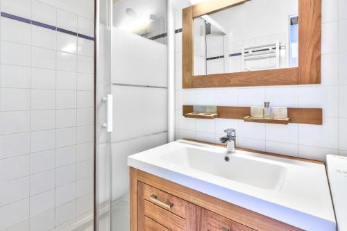 une salle de bain avec un lavabo et une douche dans l'établissement Maison pour 4 avec piscine à Lacanau, à Lacanau