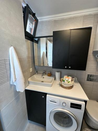 een kleine badkamer met een wasmachine en een wastafel bij House of spring in Çeşme
