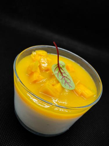 a glass bowl of orange juice with a leaf on it at Hôtel Restaurant du Lac in Boussens