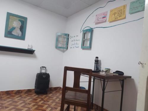 a room with a table and a chair and a wall at Hostal Casa Grande in Villazón