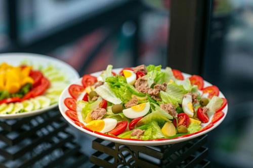 a salad in a red and white bowl on a basket at MAY DE VILLE Lakeside Hotel in Hanoi