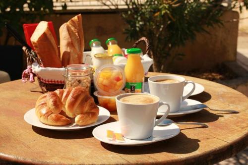 einen Tisch mit zwei Tassen Kaffee und Croissants in der Unterkunft Mont Bouquet Lodge-Résidence Hôtelière in Brouzet-lès-Alès