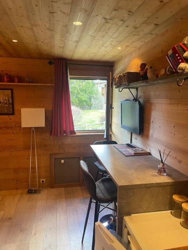 une chambre avec un bureau et une télévision dans une cabine dans l'établissement LOUE STUDIO MEGEVE, à Megève