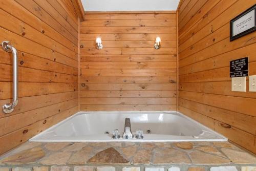 bañera en una habitación con paredes de madera en Luxury Cabin w/ Jacuzzi-Fireplace & Amazing View - Heidi, en Blairsville